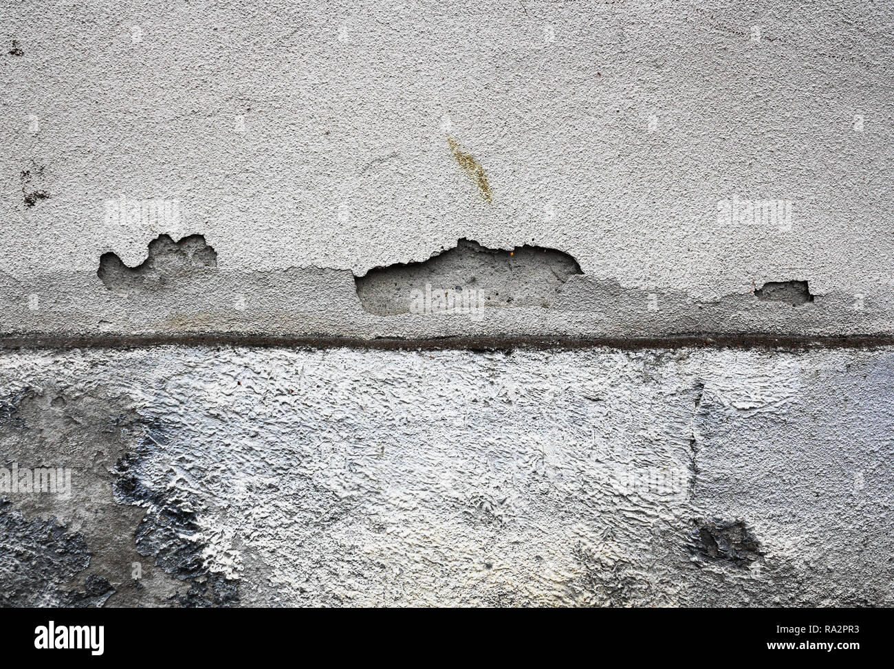 Grietas en la superficie de yeso húmedo de la pared exterior de la casa vieja Foto de stock