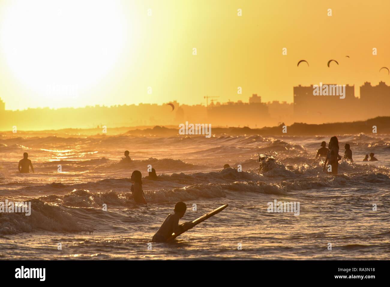 Las personas bañarse en la playa al atardecer, la playa, La Rambla, Montevideo, Uruguay Foto de stock
