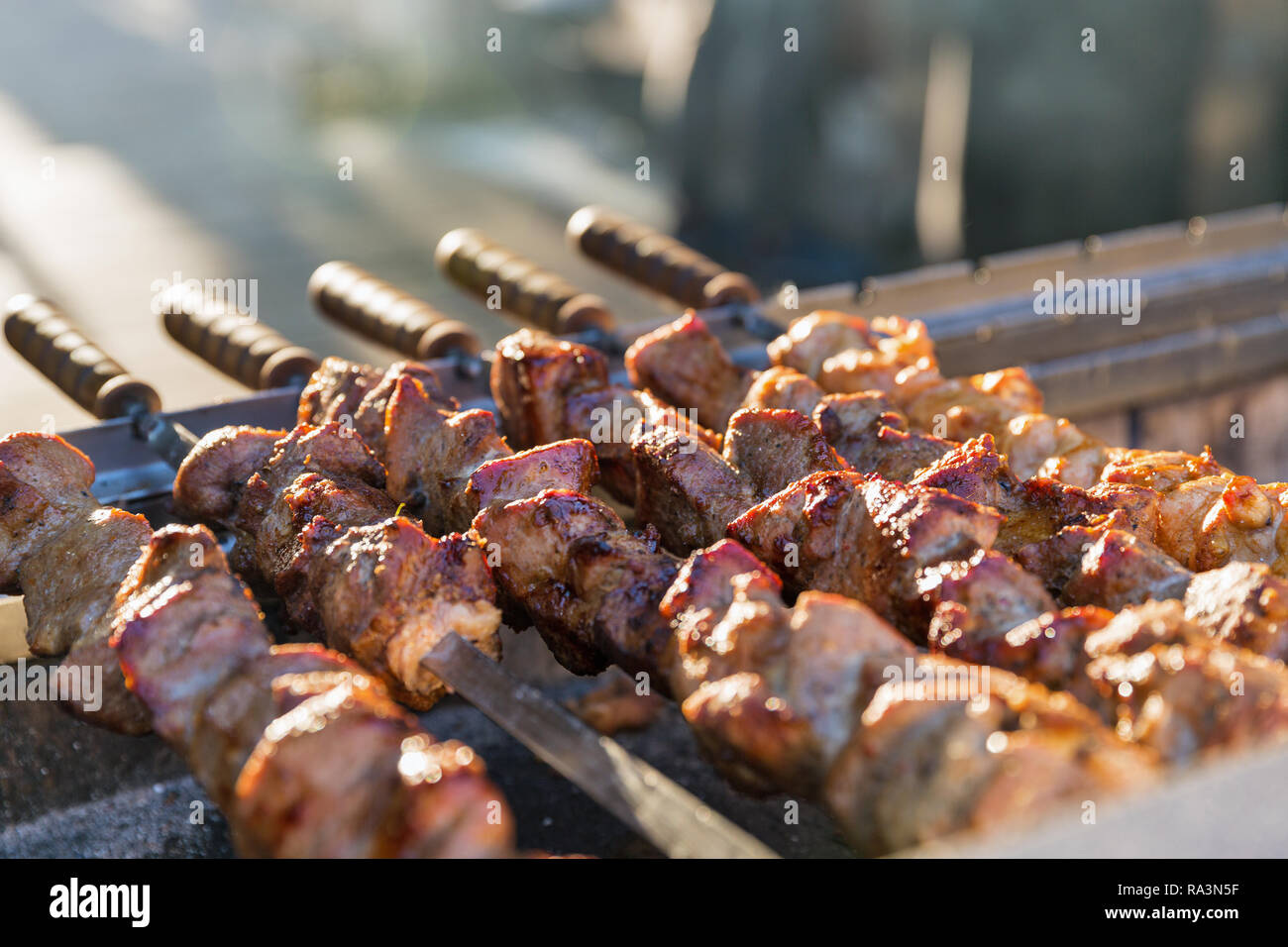 Asado a la parrilla closeup. Hecha pinchito de cubos de carne en las brochetas durante la cocción en el mangal en carbón al aire libre. Foto de stock