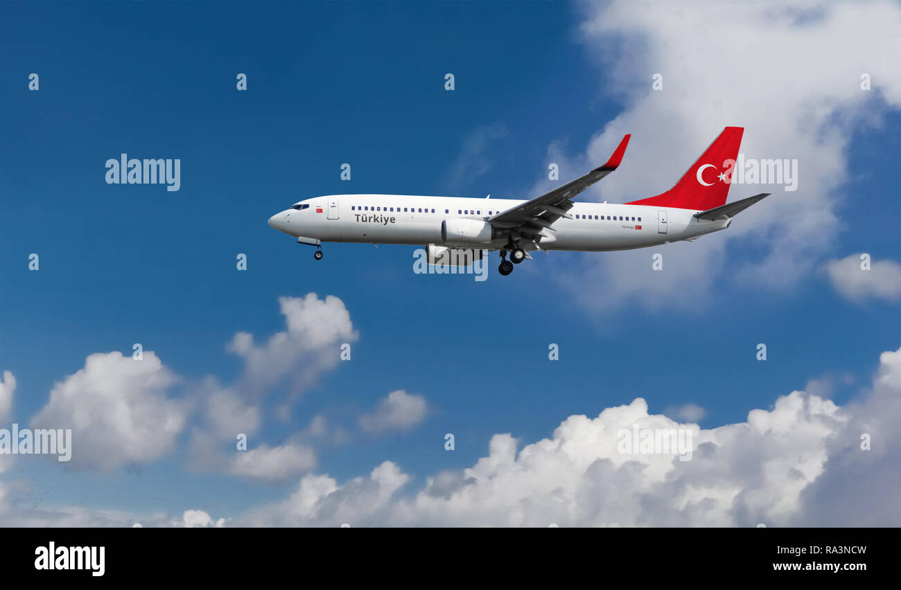 Avión de pasajeros que aterrizó en el aeropuerto con la bandera en la cola. Aviones comerciales con azul cielo nublado en el fondo Foto de stock