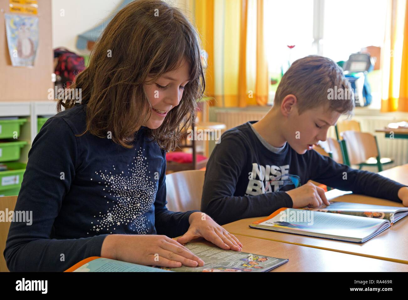 Estudiantes, niños leyendo un libro, lecciones alemanas, la escuela primaria, Baja Sajonia, Alemania Foto de stock