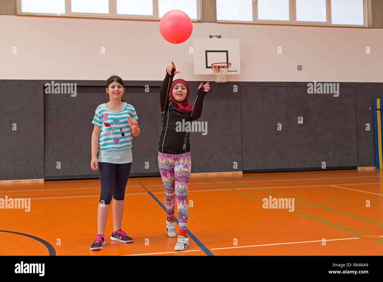 Los estudiantes jugando a la pelota en el gimnasio, la educación física, la escuela primaria, Baja Sajonia, Alemania Foto de stock