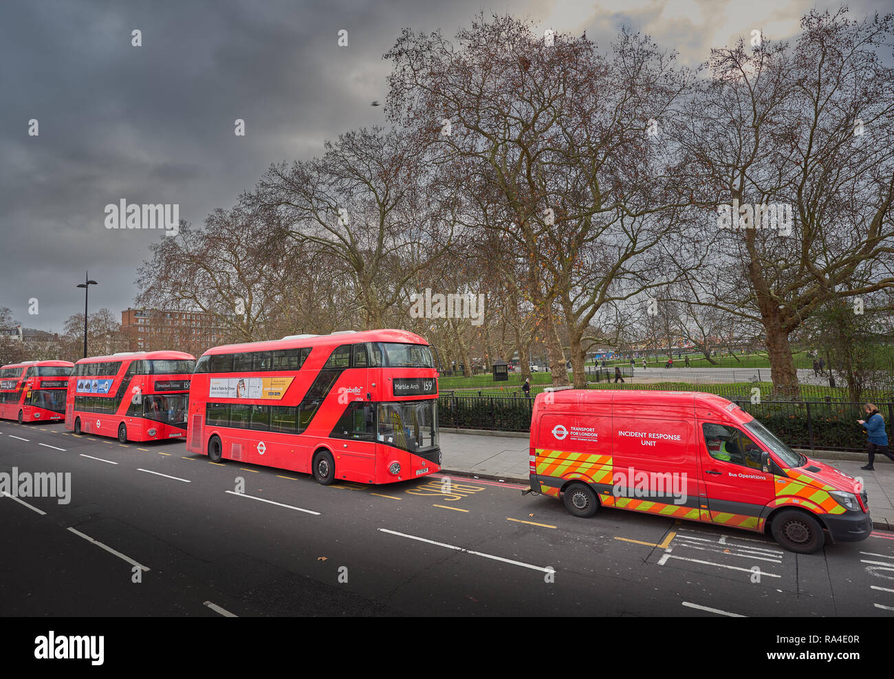 Respuesta de incidencia van delante del trío de estacionar autobuses rojos de dos pisos en Park Lane fuera de Hyde Park, Londres, Inglaterra. Foto de stock