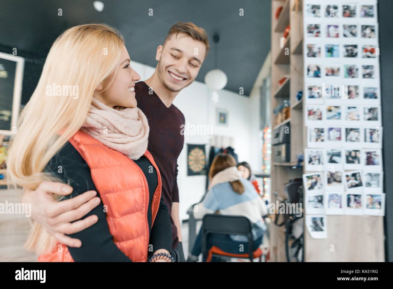Sonriente, feliz pareja abrazada en una cafetería en otoño invierno. Foto de stock