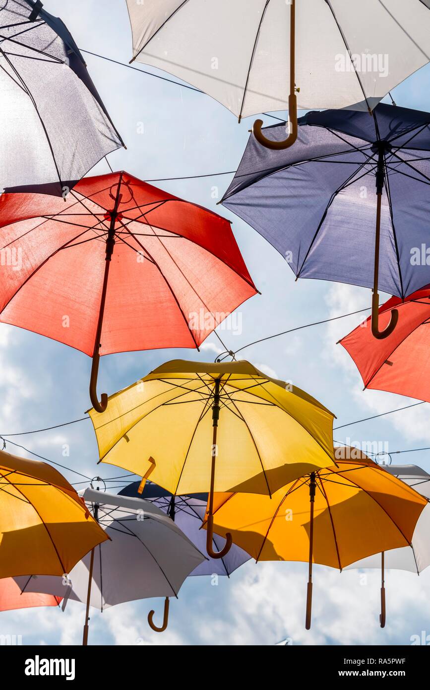 Muchos coloridos paraguas, sombrillas, colgando en el aire, el sol, Imst, Tirol, Austria Foto de stock