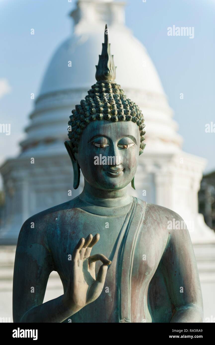 Estatua de Buda, Jnana mudra o Gyan Mudra, Dagoba blanca en la espalda, Seema Malaka templo, Lago Beira, Beira Lake, Colombo Foto de stock