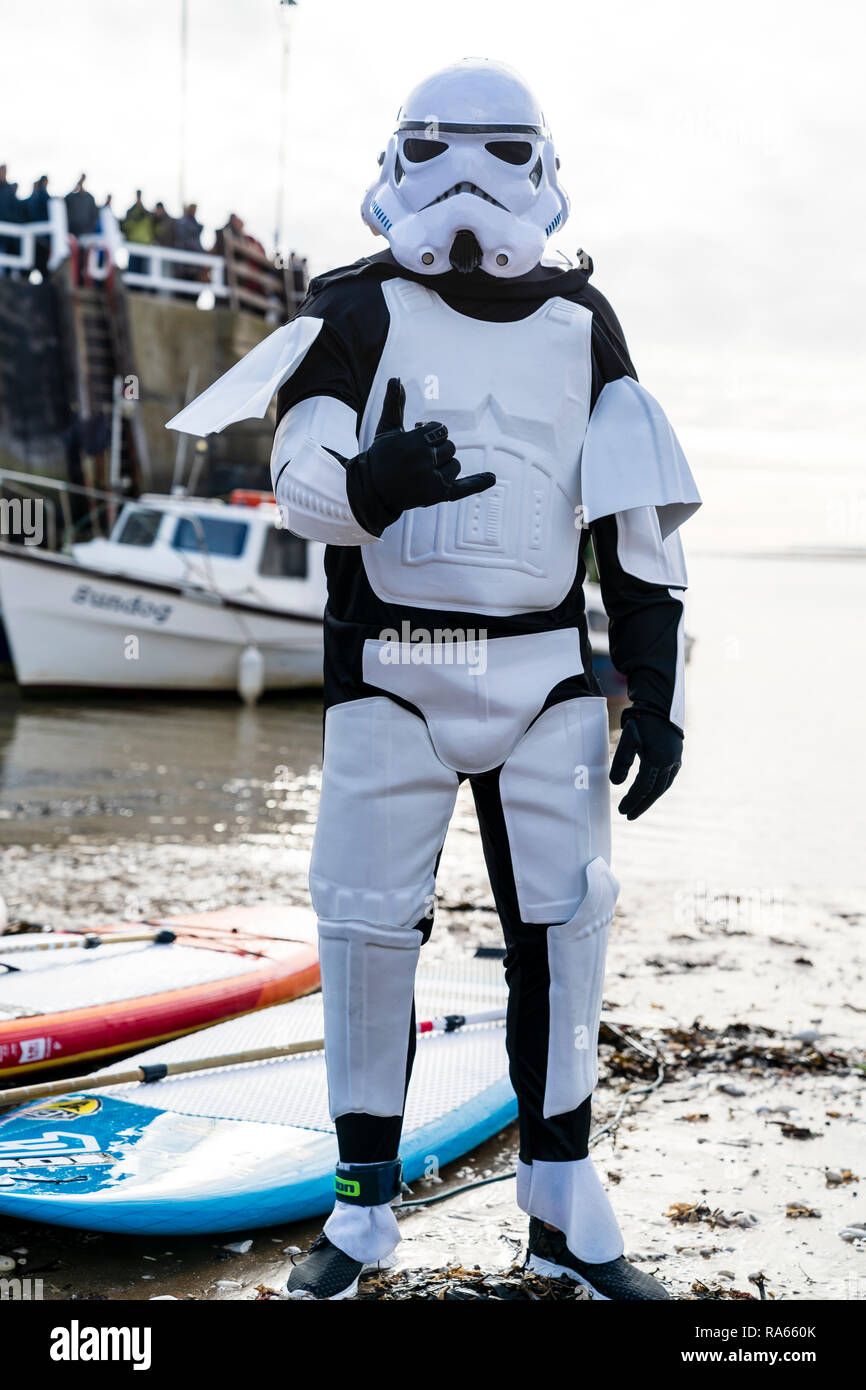 El Hombre, vestido con traje de Star Wars Star Trooper, posando en la playa  para el día de Año Nuevo anual nadar en Broadstairs. Mirando, de pie en la  orilla del mar,