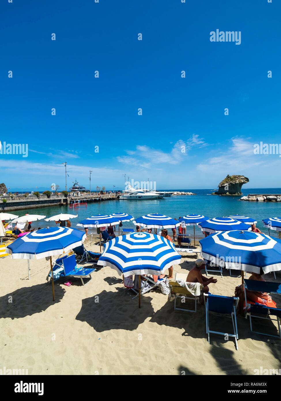Sombrillas, Corso Angelo Rizzoli, playa detrás de roca de toba il Fungo, Lacco Ameno, isla ischia, en el Golfo de Nápoles, Campania, Italia Foto de stock
