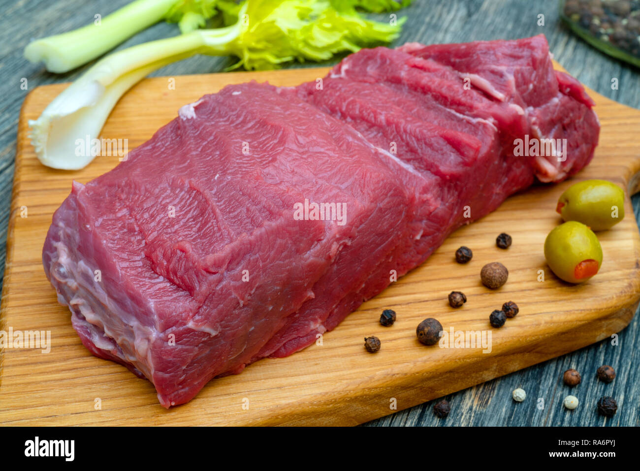 Trozo de carne magra fresca cruda sobre una tabla para cortar la carne. Foto de stock
