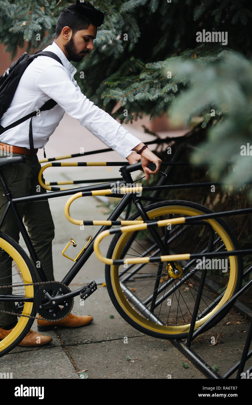 Negocios, estilo de vida, el transporte y el concepto de la gente joven - hombre indio de aparcamiento en la calle Ciudad de bicicletas Foto de stock