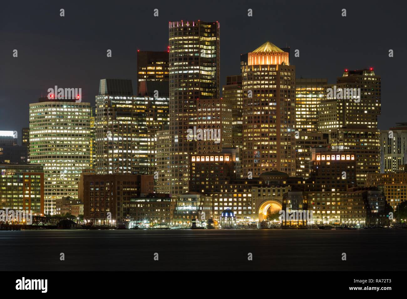 Vistas del perfil de la ciudad de Boston en la noche, rascacielos, delante del canal principal de Boston, Boston, Massachusetts, EE.UU. Foto de stock