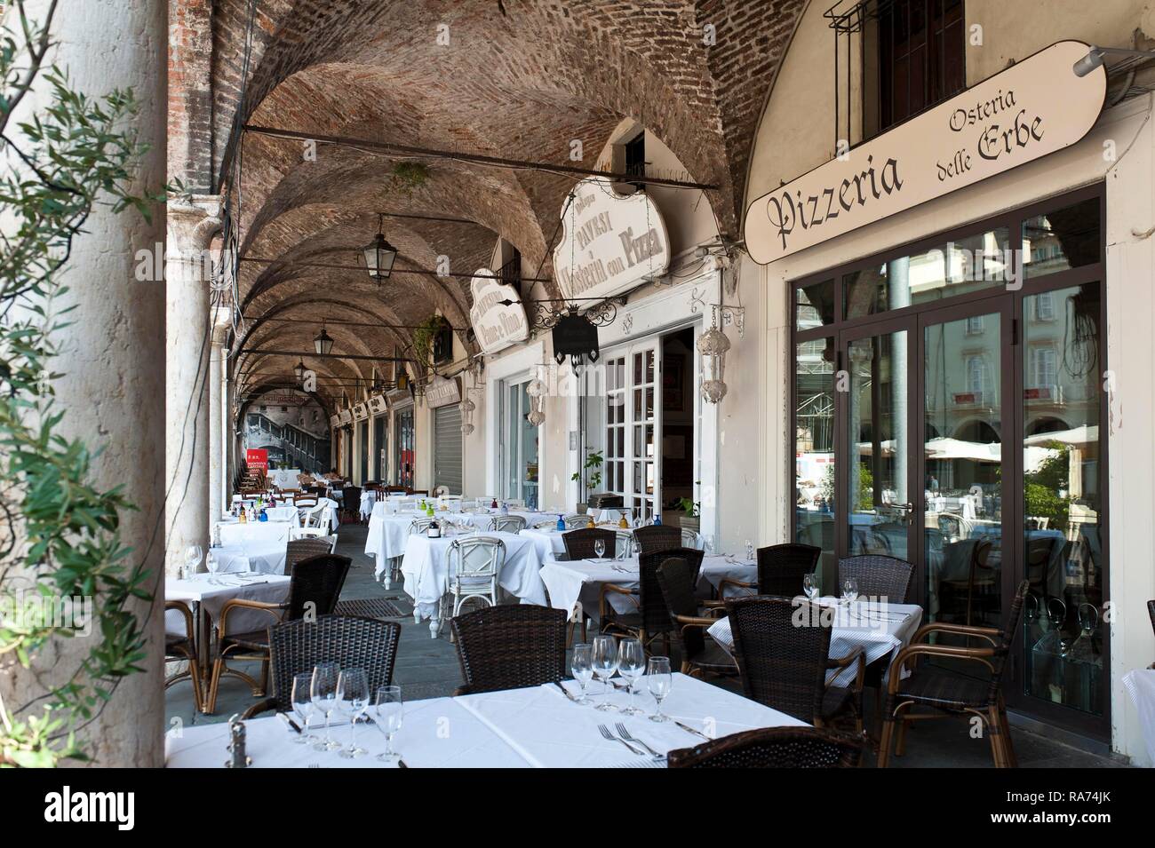 La gastronomía italiana, restaurante bajo las arcadas, pizzería Osteria delle Erbe, Mantua, Lombardía, Italia Foto de stock