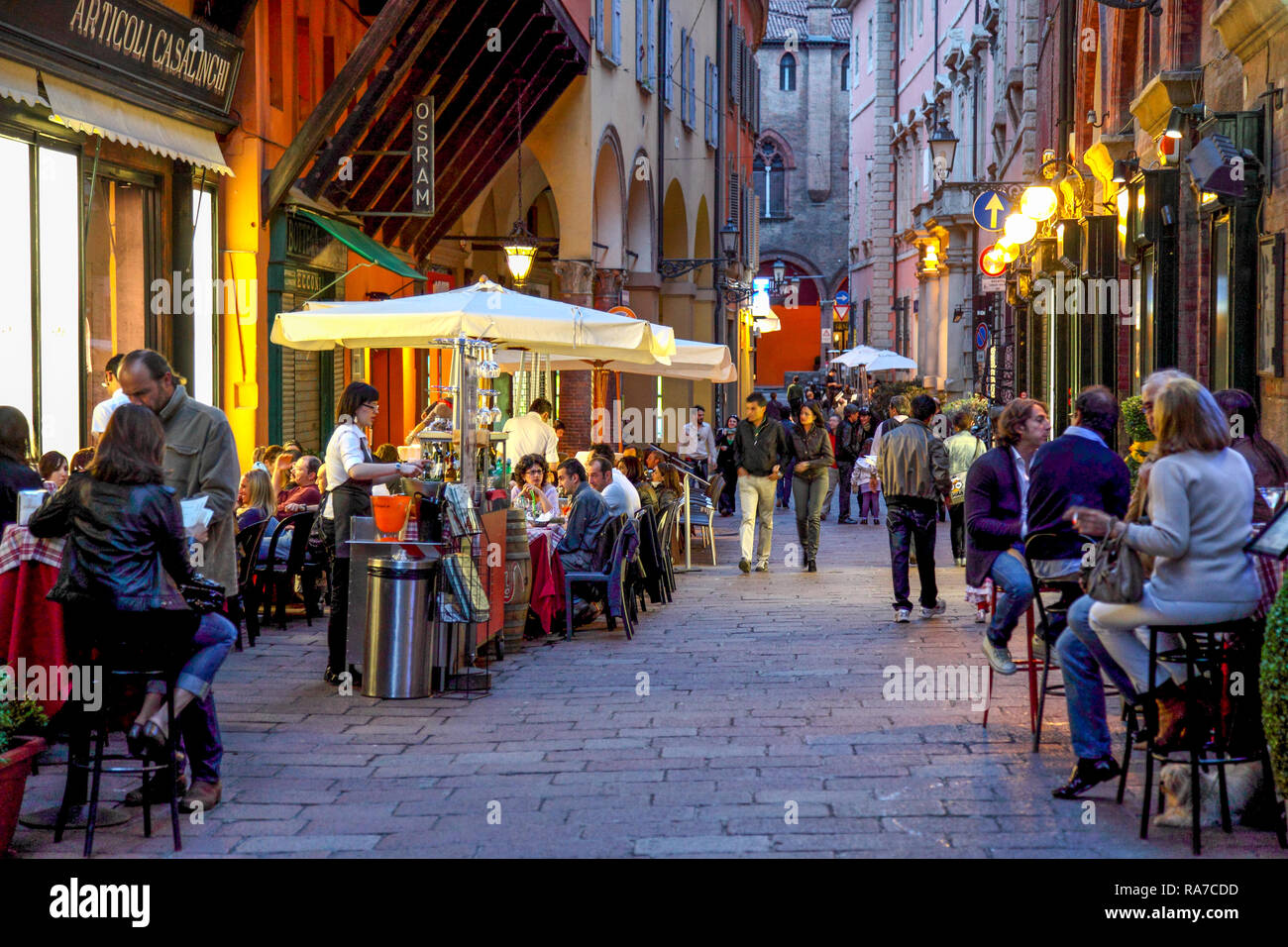 Calle peatonal y cafeterías al aire libre durante la noche en Bolonia, Italia. Foto de stock