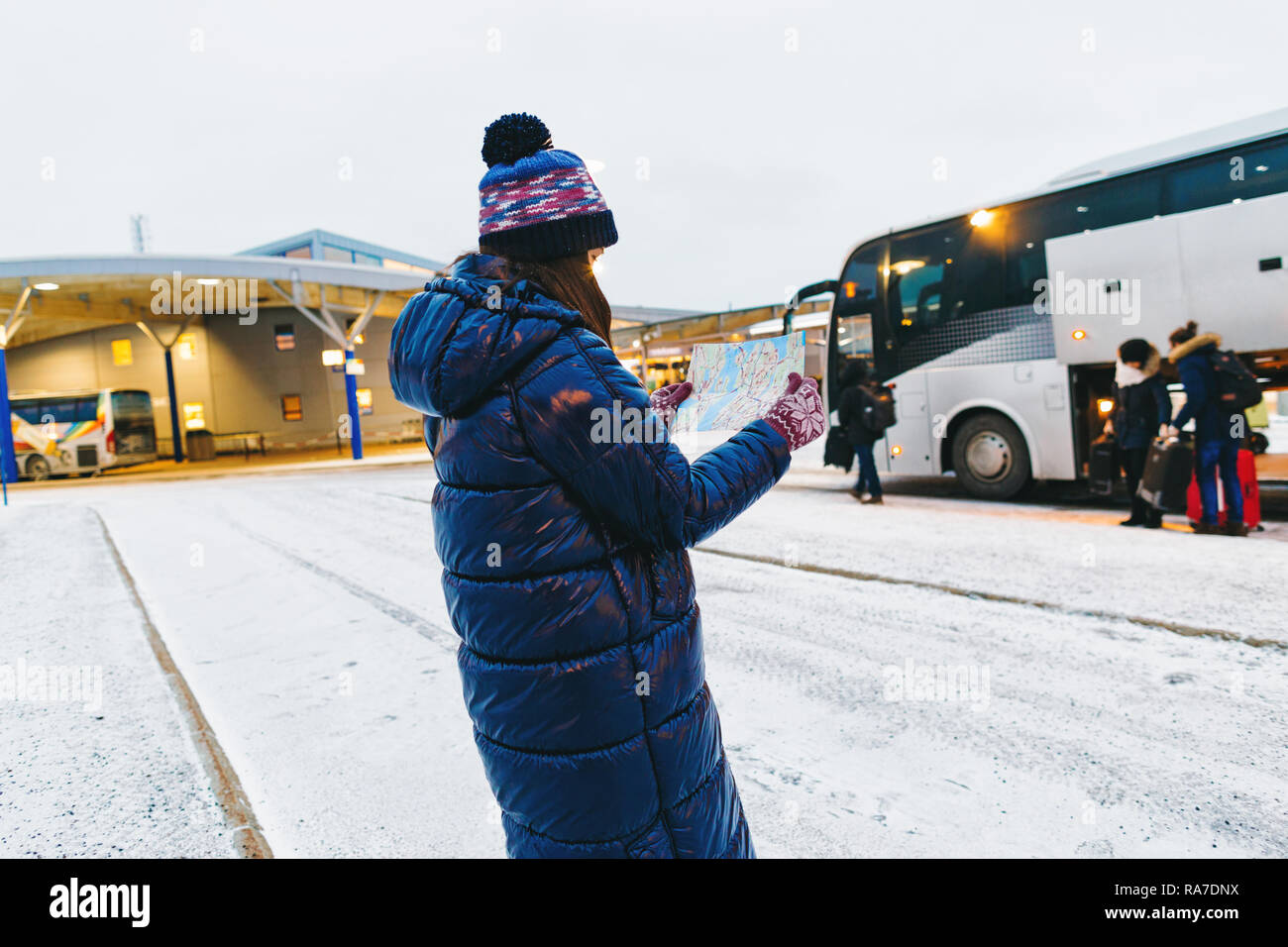 Estilo de viaje. Joven viajero en la terminal de ómnibus de Suecia busca en el mapa Foto de stock