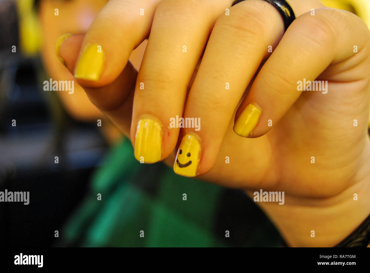 Esmalte de uñas de color amarillo con negro sonrisa sobre ella Fotografía  de stock - Alamy