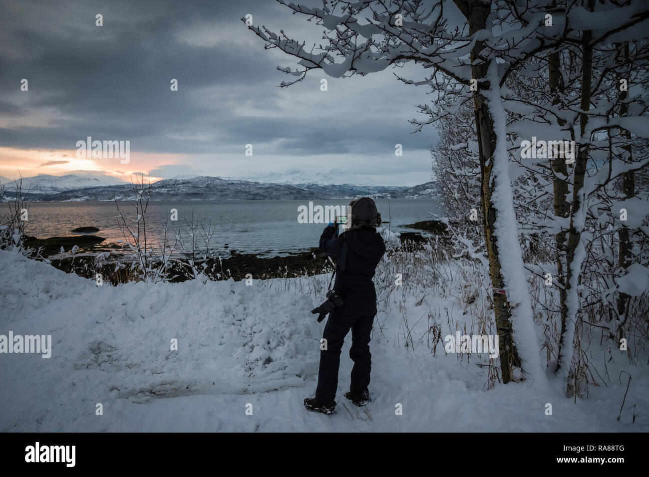 Hembra fotógrafo captar nevadas invernales en Finnsnes, Noruega. Foto de stock