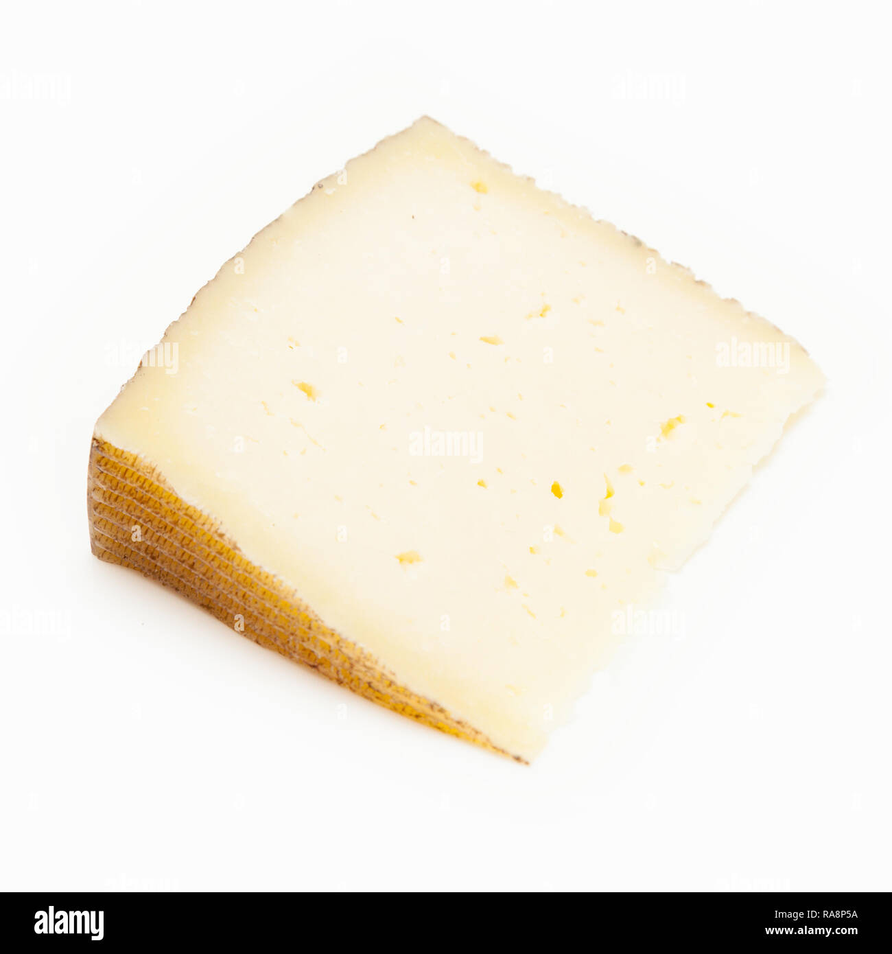 Castellano Manchego queso hecho con leche de oveja tiene una textura firme y cremosa, aislado en un fondo blanco studio. Foto de stock