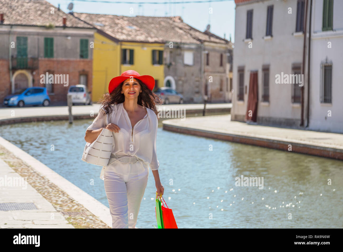 Turista contento con gran sombrero caminando en ciudad italiana. Ella tiene características somáticas Easterm media Foto de stock