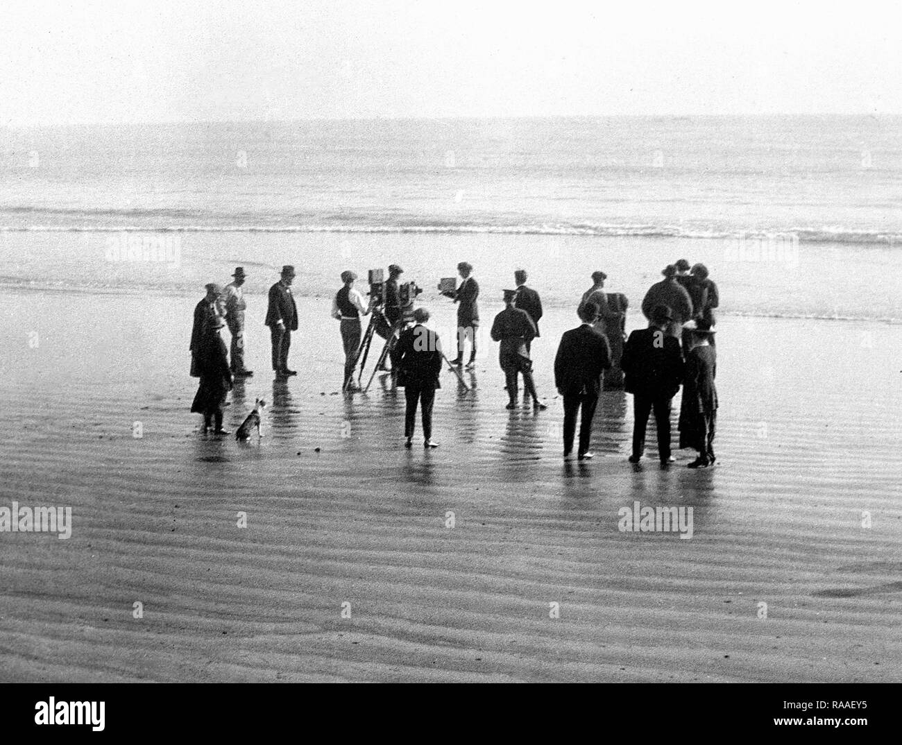 Un equipo de filmación y un perro de trabajo en una playa de California, 1925. Foto de stock