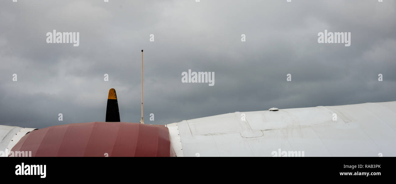 Comienzo de la vendimia de alas de avión y cabina con un fondo de cielo nublado oscuro Foto de stock