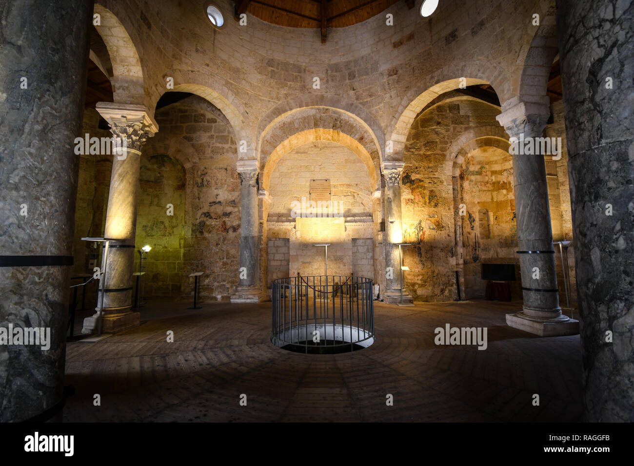 Interior de la Iglesia de San Giovanni al Sepolcro en la ciudad de Brindisi (Italia), mostrando las columnas de mármol y granito y la muralla medieval frescos Foto de stock