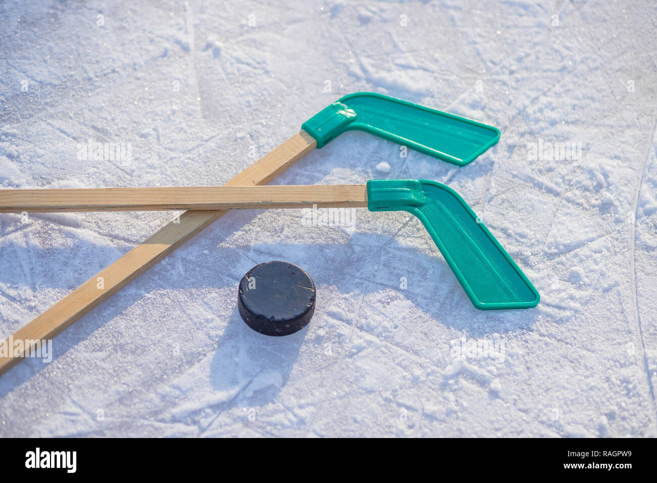Palo de Hockey sobre hielo y puck en los soleados días de invierno.Los  deportes de invierno para las actividades al aire libre.disco de hockey  stick y colocación sobre el hielo con textura