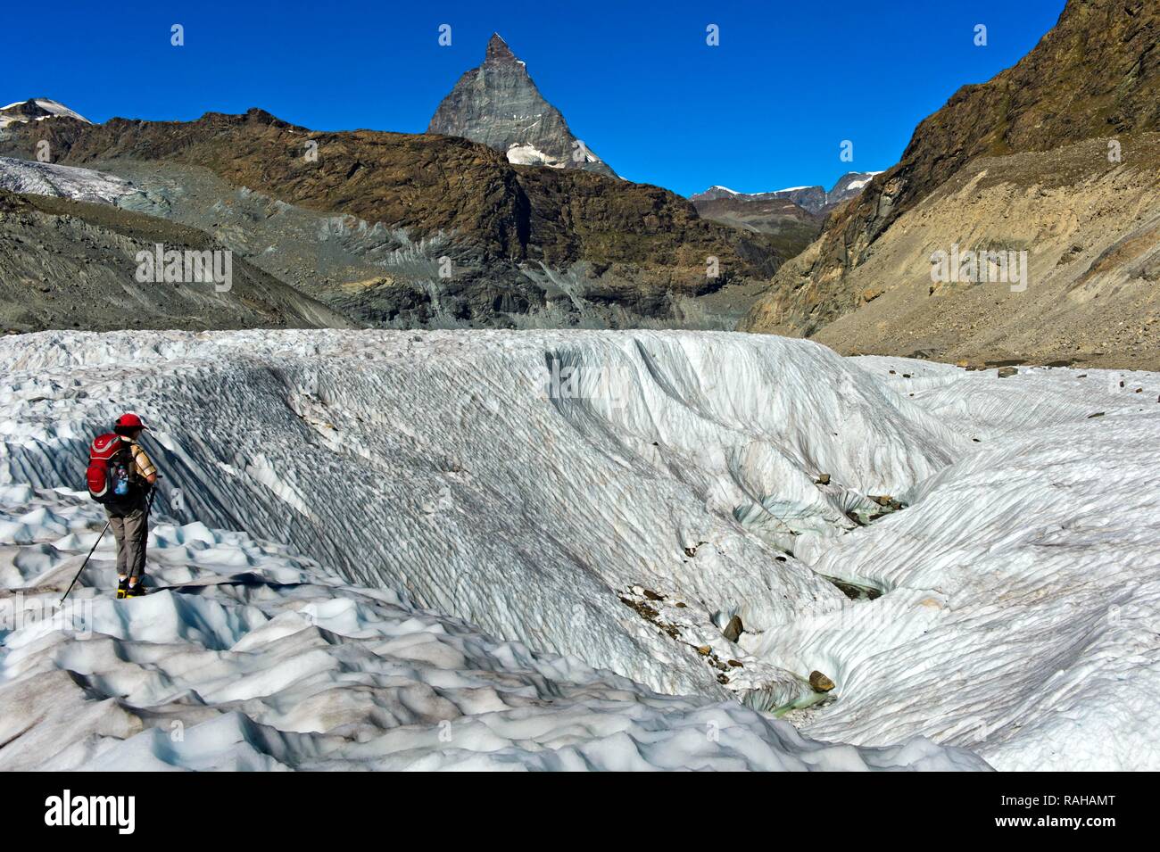 Montañero de pie en un círculo de hielo sobre el Gornergletscher, detrás del Matterhorn, Zermatt, Vales, Suiza Foto de stock