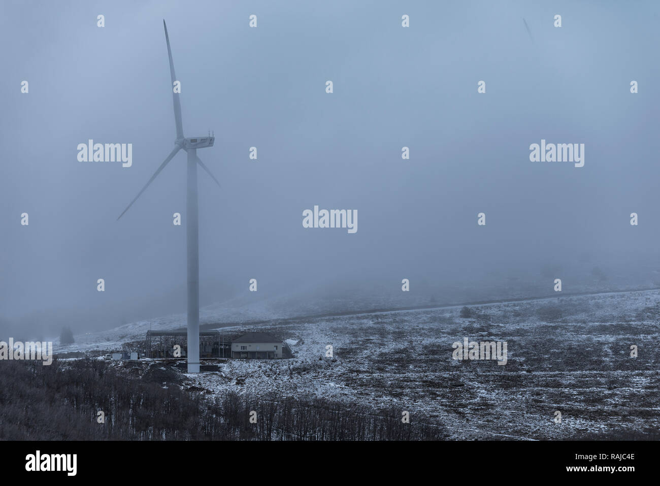 Paisaje invernal con turbinas de viento y nubes en un campo cubierto de nieve de montaña Foto de stock