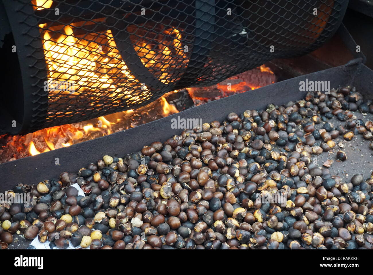 Castañas tostado por el fuego con artilugios de un país en un mercado al aire libre Foto de stock