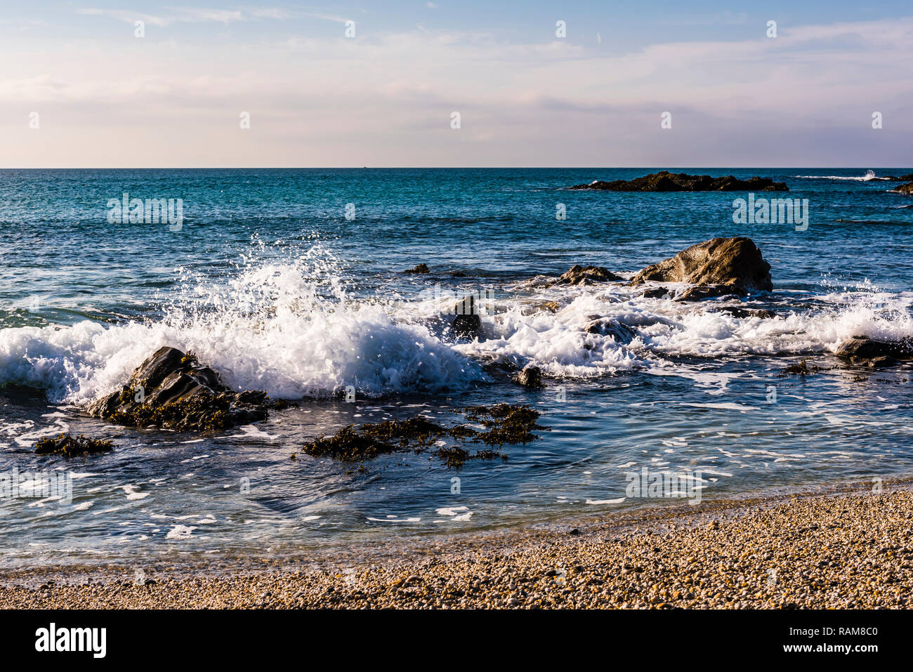 Olas rompiendo sobre las rocas en Fistral Beach, Newquay, Cornwall, Reino Unido Foto de stock