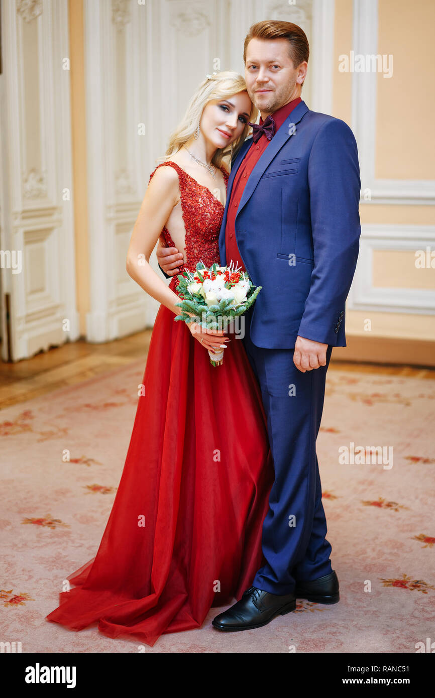 Una mujer hermosa en un vestido rojo destaca con un hombre, la novia y el  novio, felices recién casados Fotografía de stock - Alamy