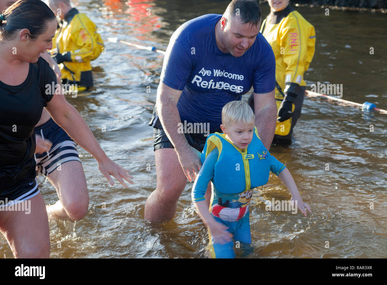 Joven tomando parte en el día de Año Nuevo nadar en Rhu Marina, Escocia Foto de stock