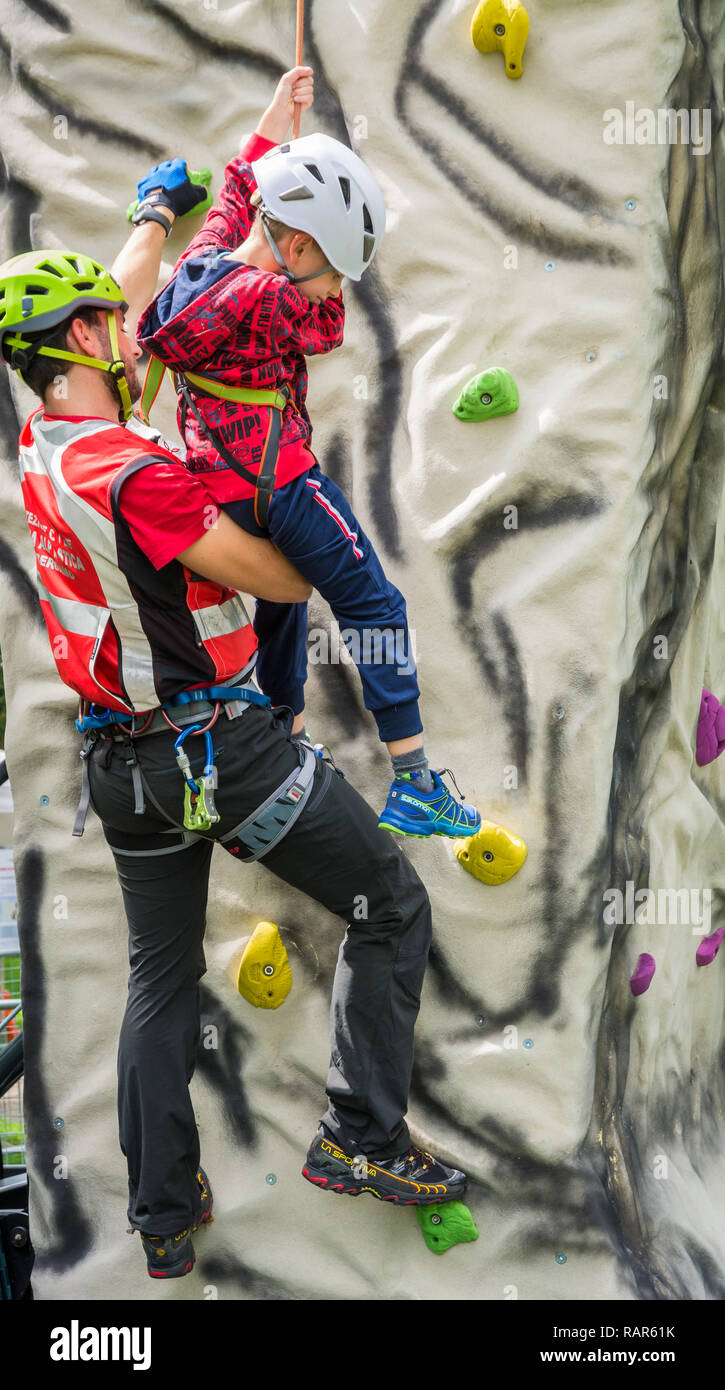 Trabajar con instructor macho joven en muro de escalada Foto de stock
