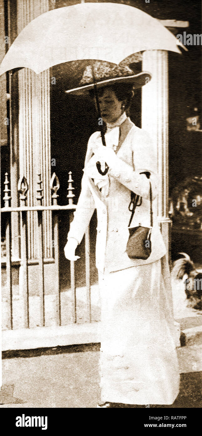 Mujer con sombrilla, sombrero y bolso, vistiendo un traje deportivo, visto en Cowes, Isla de Wight en el Reino Unido en 1913 Foto de stock