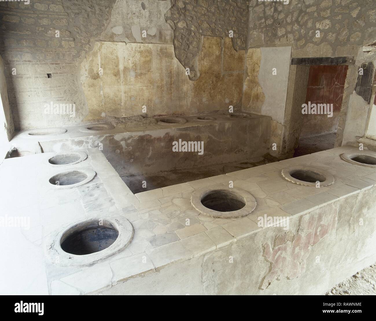 Italia. Pompeya. Antigua ciudad romana destruida por la erupción del Vesubio en el año 79 D.C. Barra de bar con agujeros donde tarros fueron establecidos en ellos (dolia) para la comida o el vino. La Campania. Foto de stock