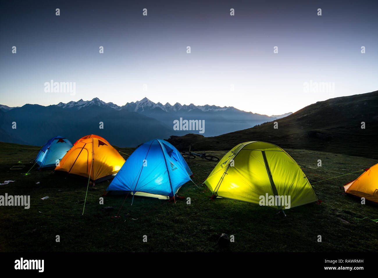 Una fila de tiendas de campaña en la madrugada Khalia arriba por encima de la ciudad de Munsyari en Uttarakhand, al norte de la India, en los Himalayas. La Panchchuli picos en la distancia. Foto de stock