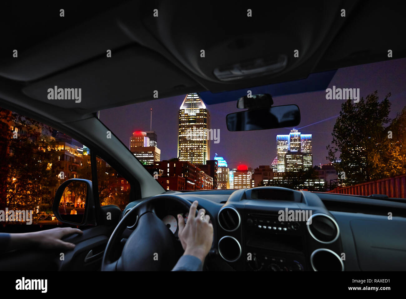El joven piloto dentro del coche en la carretera en busca de una ciudad  paisaje nocturno Fotografía de stock - Alamy