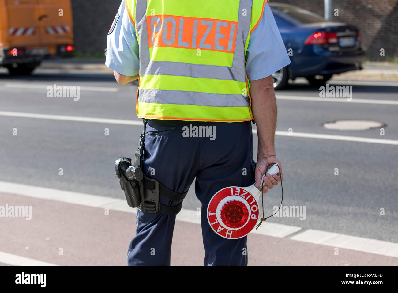 Policía con chaleco amarillo y detener llana, durante un control de  tráfico, Alemania Fotografía de stock - Alamy
