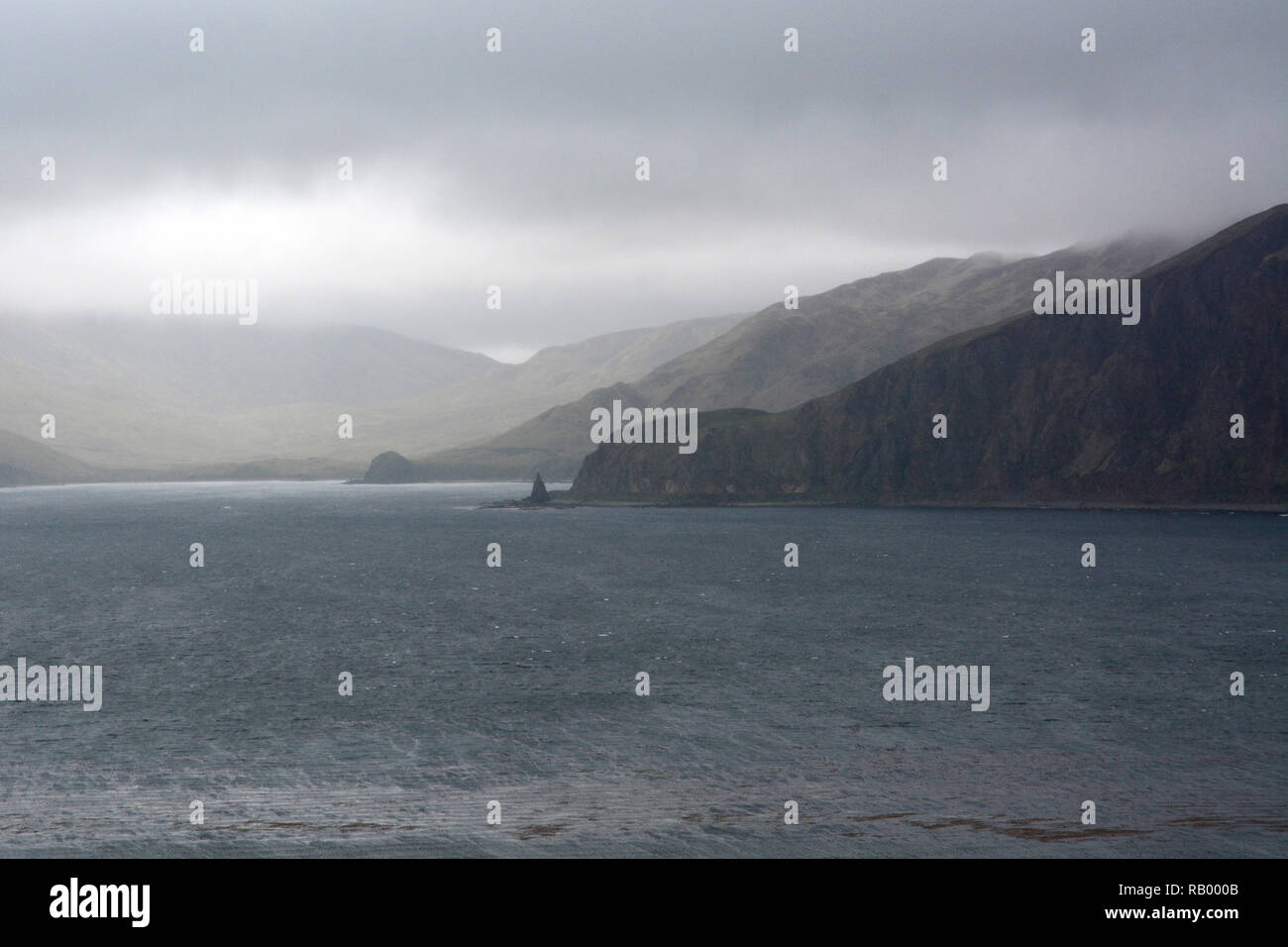 Las nubes y la lluvia pesada a lo largo de la costa del Mar de Bering Isla Unalaska, en la cadena de las Islas Aleutianas, Alaska, Estados Unidos Foto de stock