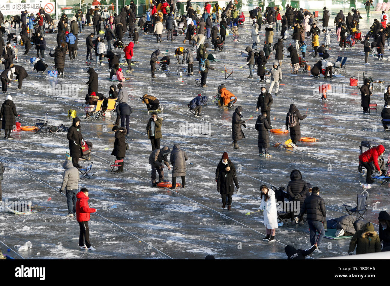 Hwacheon, Corea del Sur. 5 de enero, 2019. Enero 5, 2019-Hwacheon, Sur Korea-Visitors líneas fundido a través de orificios perforados en la superficie de un río congelado durante un concurso de captura de trucha en Hwacheon, Corea del Sur. El concurso es parte de un festival anual de hielo que atrae a más de un millón de visitantes cada año. Crédito: Ryu Seung-Il/Zuma alambre/Alamy Live News Foto de stock