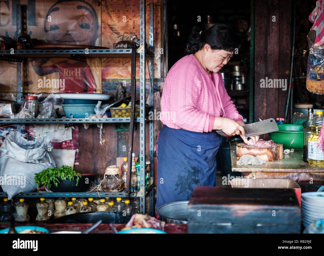 KYAING Tong, Myanmar: CIRCA DICIEMBRE 2017: mujer birmana cocina en su restaurante en la Loi Mwe Hill Village. El estado de Shan en torno a Kyaing Tong en Mya Foto de stock