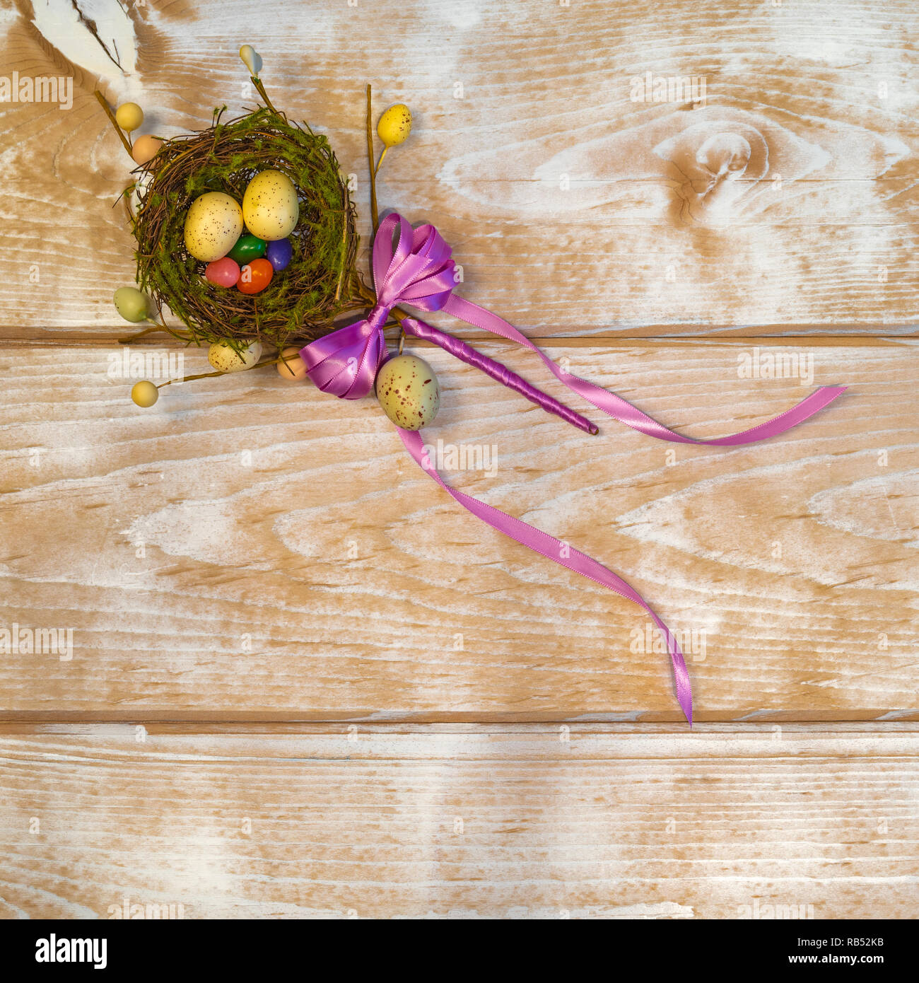 Fondo de vacaciones de Pascua con huevos de Pascua y Jelly Beans en un nido de pájaros en un fondo de madera. Foto de stock