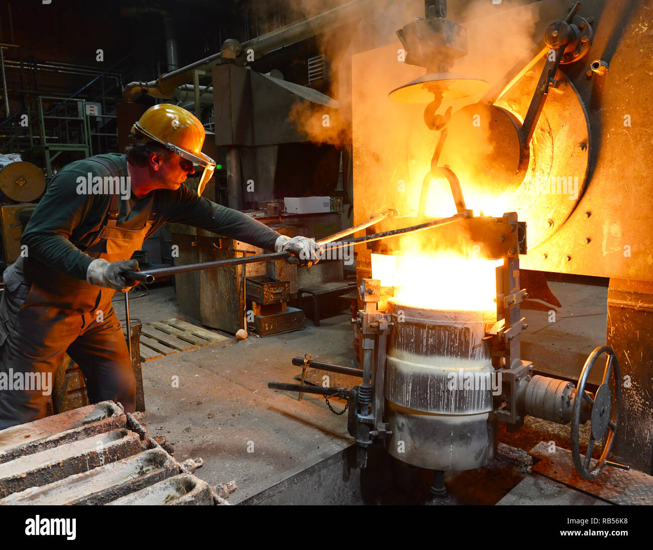 Los trabajadores en una pieza de metal de fundición - Seguridad en el trabajo y el trabajo en equipo Foto de stock