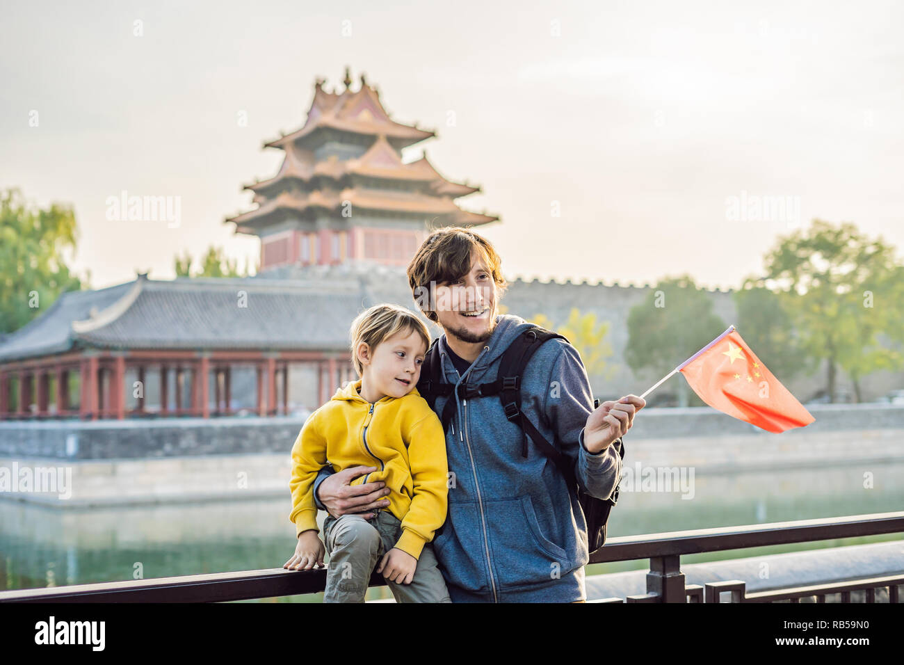Disfrutar de vacaciones en China. Familia Feliz con bandera nacional