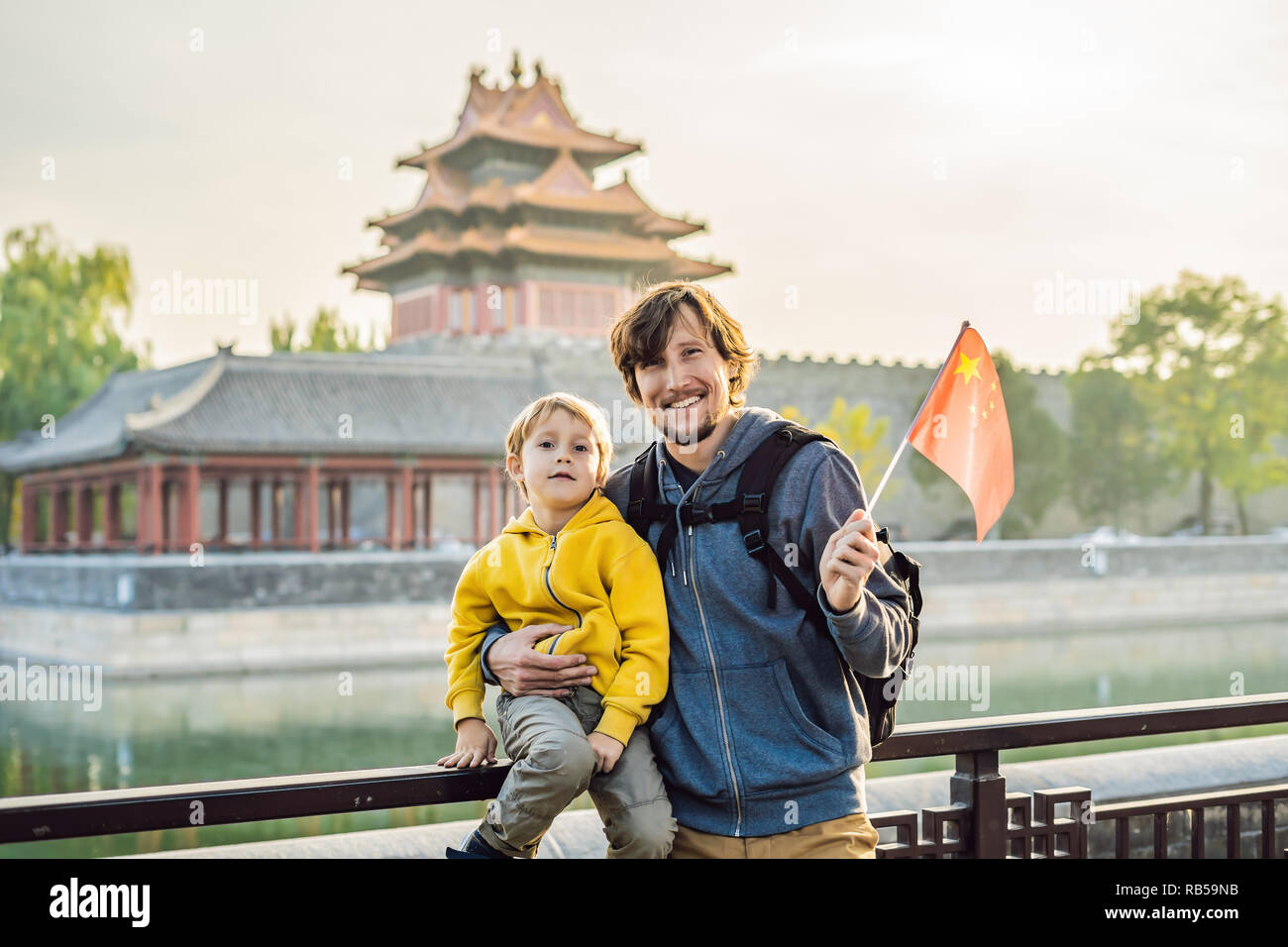 Disfrutar de vacaciones en China. Familia Feliz con bandera nacional chino  en la Ciudad Prohibida. Viaje a China con niños concepto. Visa de tránsito  libre 72 horas, 144 horas en China Fotografía