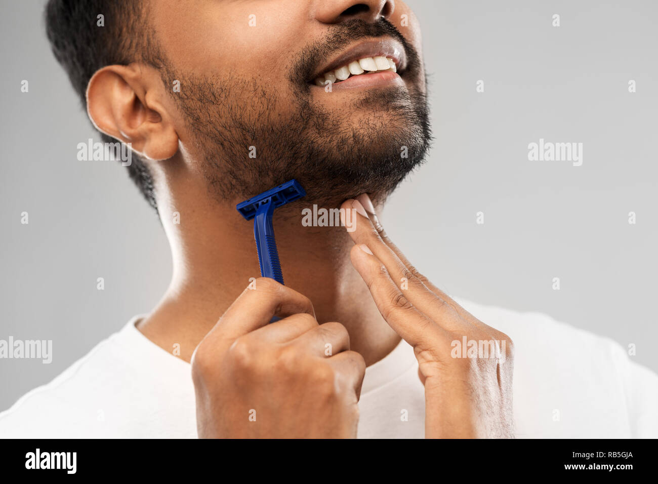 Hombre afeitarse la barba con una máquina de afeitar eléctrica Fotografía  de stock - Alamy