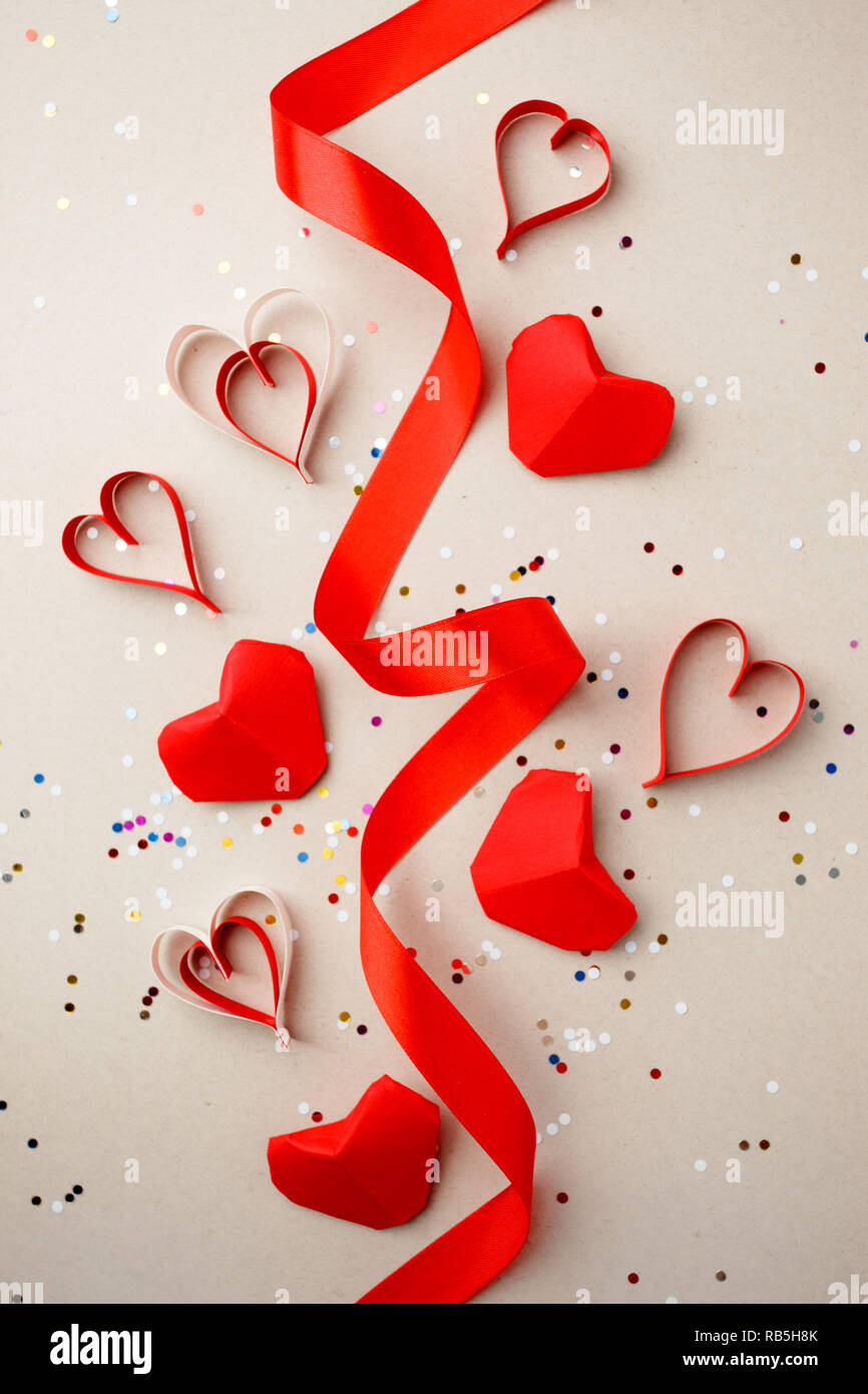 Corazones de papel rojo y cintas de seda, confeti sobre fondo gris. Día de  San Valentín absctract. Símbolo del amor. Copie el espacio, laicos plana  Fotografía de stock - Alamy