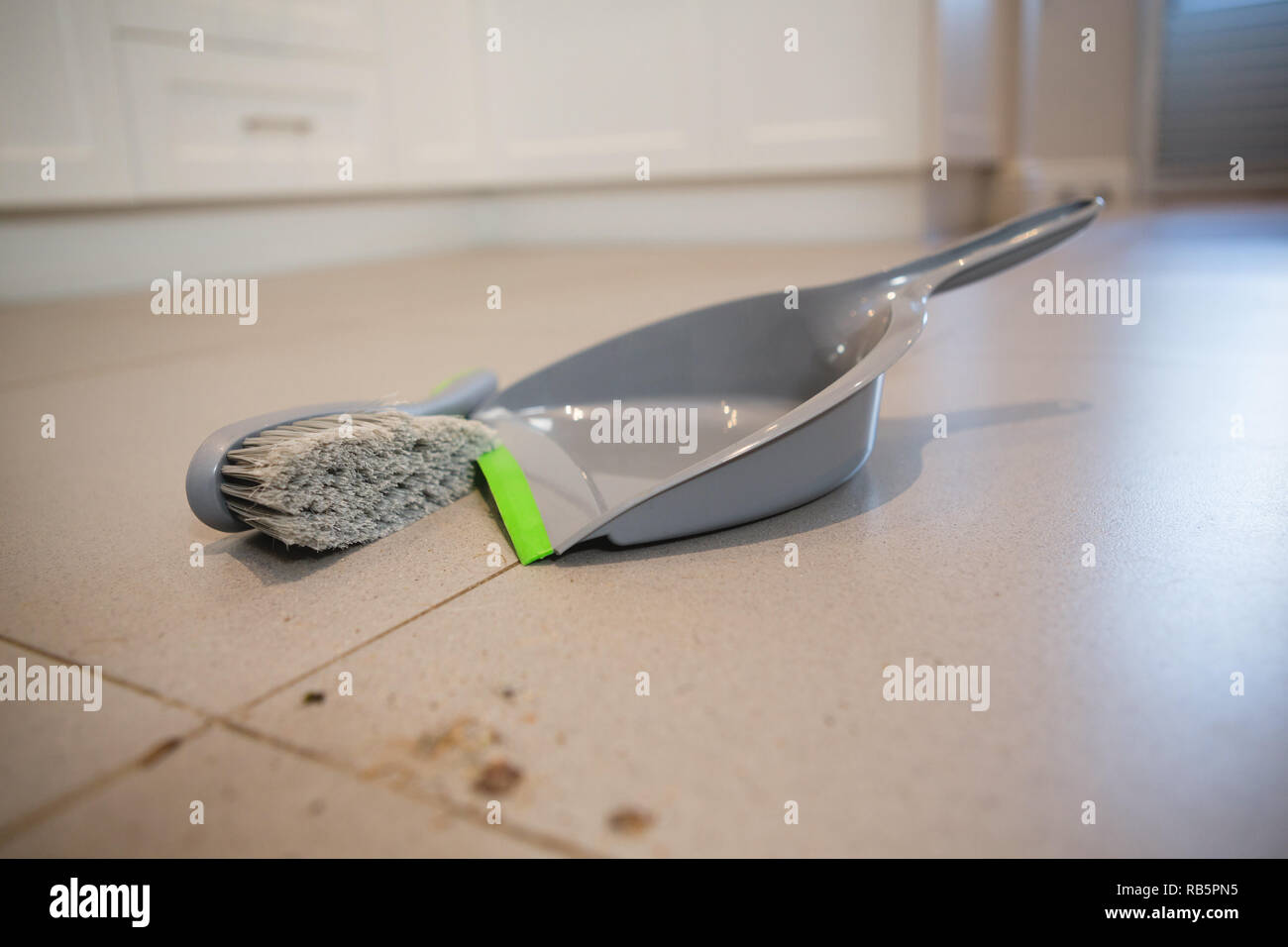 Bandeja de polvo y cepillo en un piso en casa Foto de stock