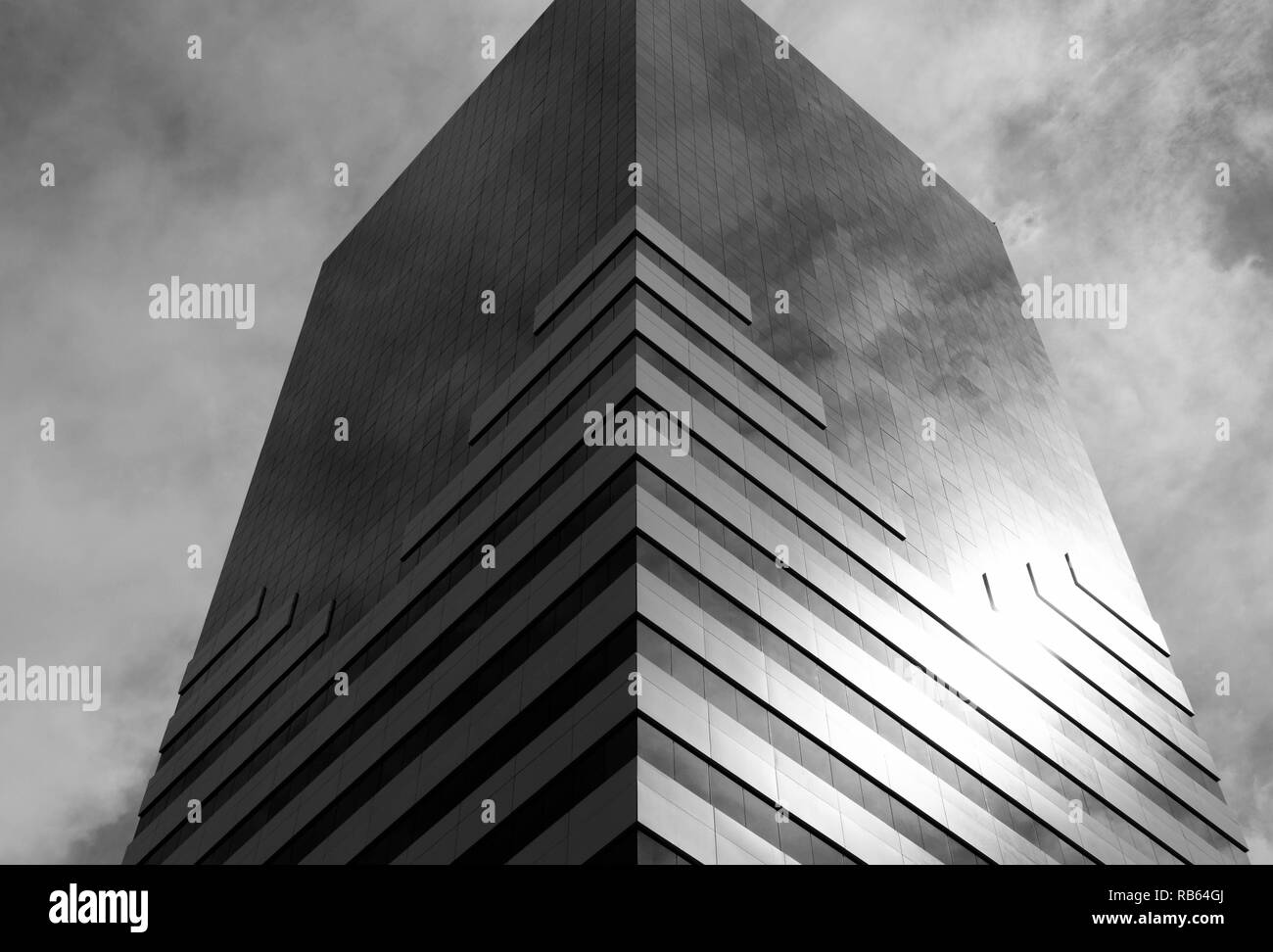 Construcción de un espejo visto desde abajo que refleja el cielo, en blanco y negro. Foto de stock