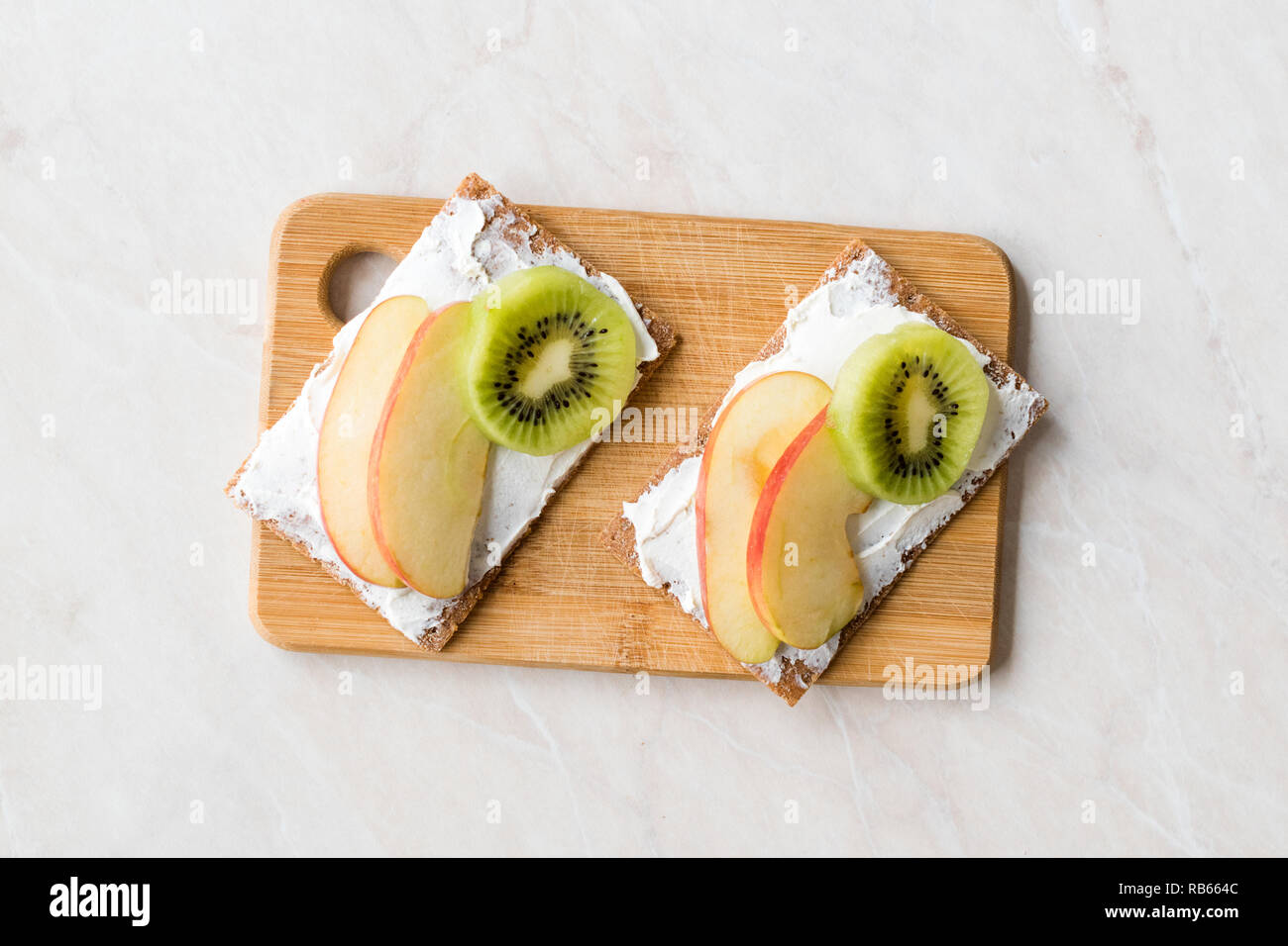 Centeno Cripsbread con crema de queso, trozos de manzana y Kiwi / aperitivos  saludables receta con alimentos orgánicos Fotografía de stock - Alamy